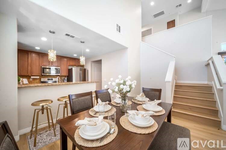 A dining room with a table set for a meal.