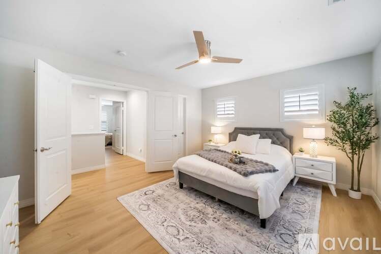 A bedroom with a bed, nightstand, and a ceiling fan.