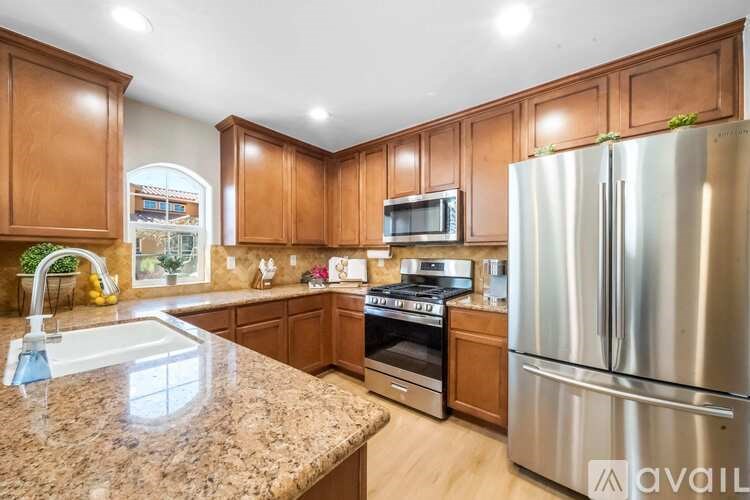 A kitchen with wooden cabinets and a granite countertop.
