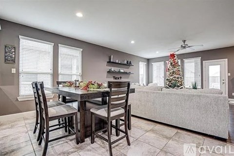 A dining room with a table set for six and a Christmas tree in the corner.