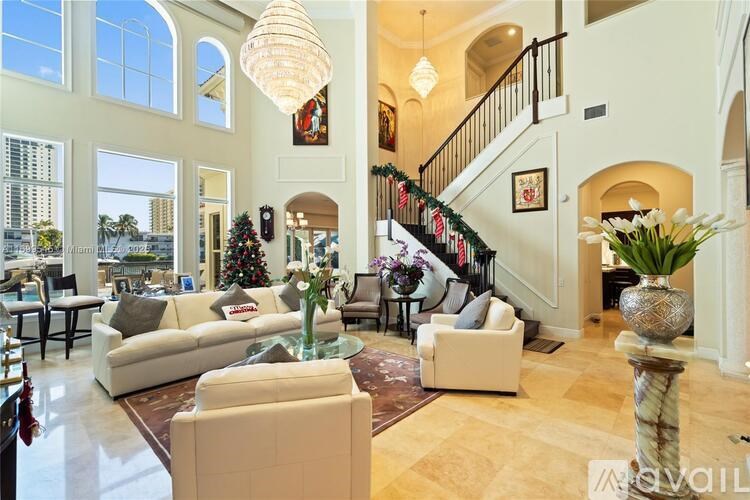 A large, well-furnished living room with a staircase and a Christmas tree.