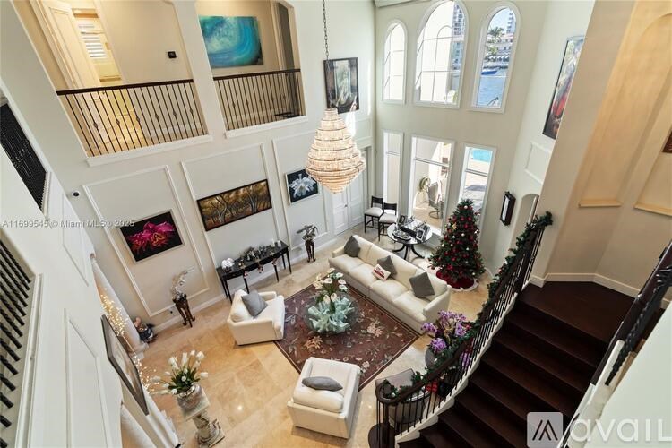 A large, well-decorated living room with a staircase on the left side.