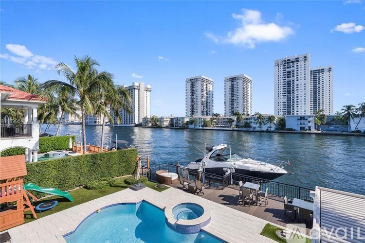 A pool and hot tub are on a patio overlooking a body of water.