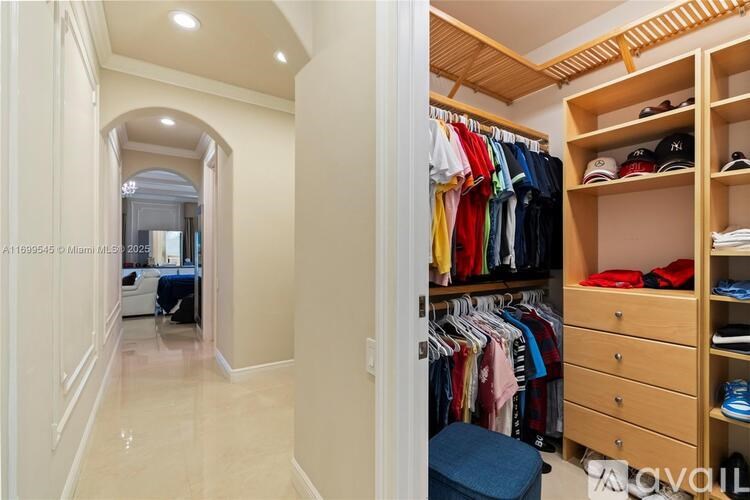 A walk-in closet with clothes and shoes on shelves.