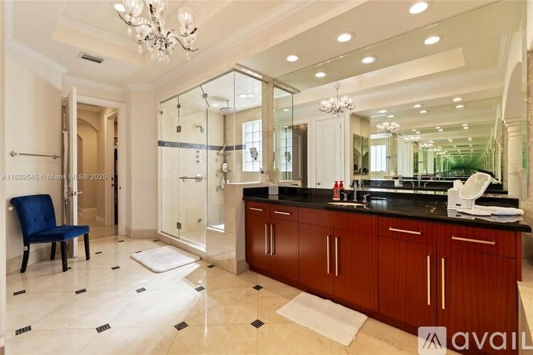 A bathroom with a blue chair and a vanity with a mirror above it.