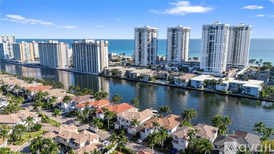 A coastal cityscape with apartment buildings and palm trees.