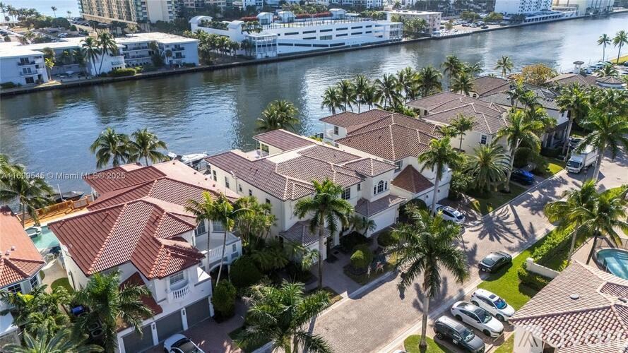 A view of a residential area with houses and palm trees.