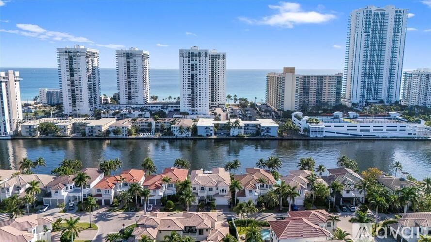 A coastal cityscape with a mix of residential and high-rise buildings.
