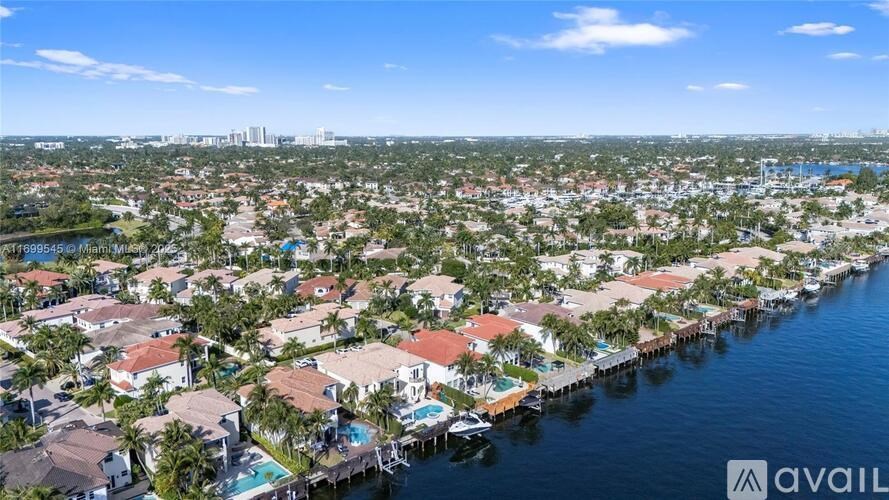 A bird's eye view of a residential area with a body of water in the foreground.