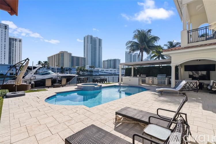 A pool area with a table and chairs in front of a building.