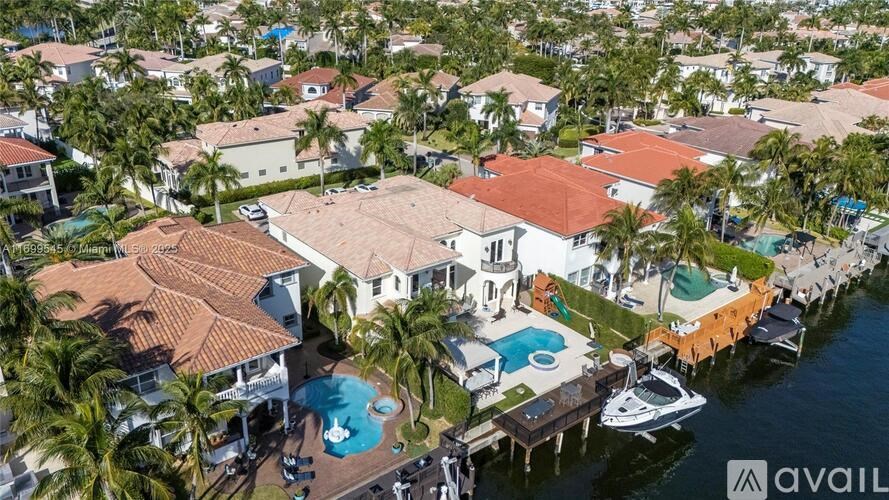 A large house with a pool and a boat in front of it.