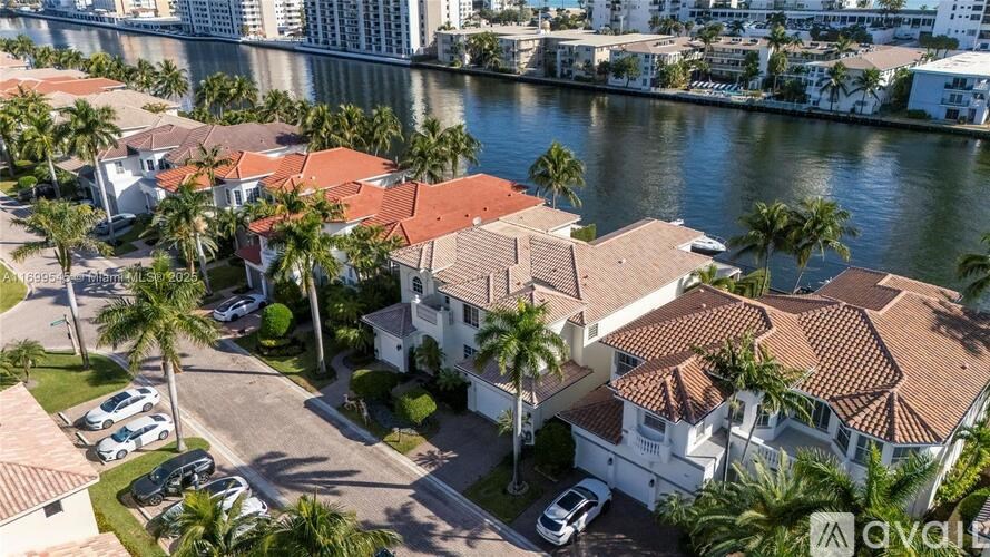 A bird's eye view of a residential area with houses and palm trees.
