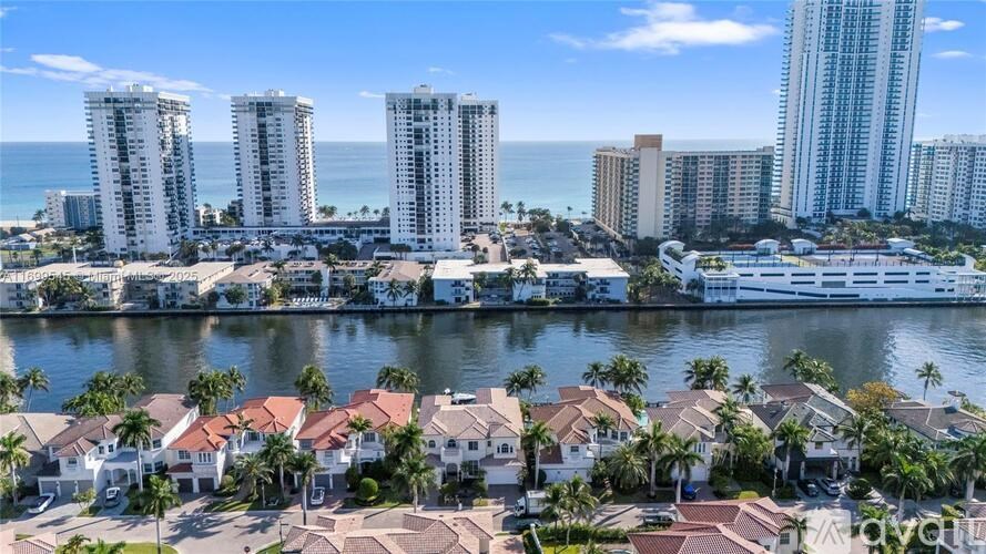 A coastal cityscape with apartment buildings and palm trees.