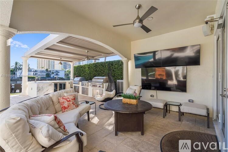 A patio with a white couch, a table, and a ceiling fan.