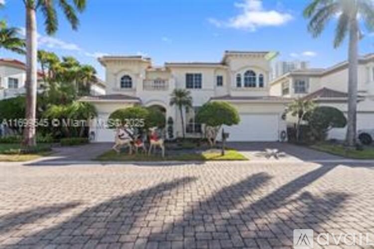 A large white house with a driveway in front.