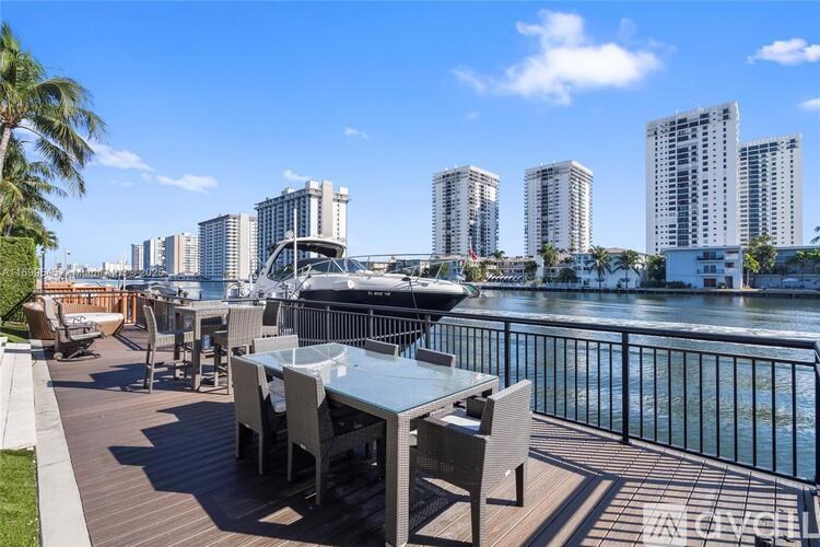 A table and chairs are on a deck overlooking a body of water.