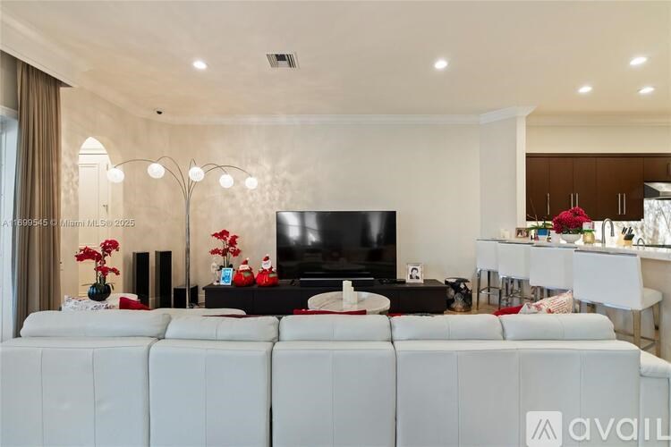 A modern living room with a white sofa and a black television.
