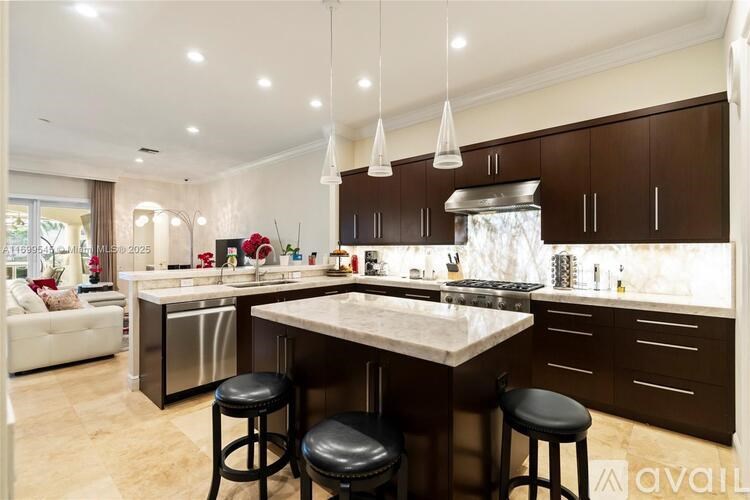 A modern kitchen with a large island and bar stools.