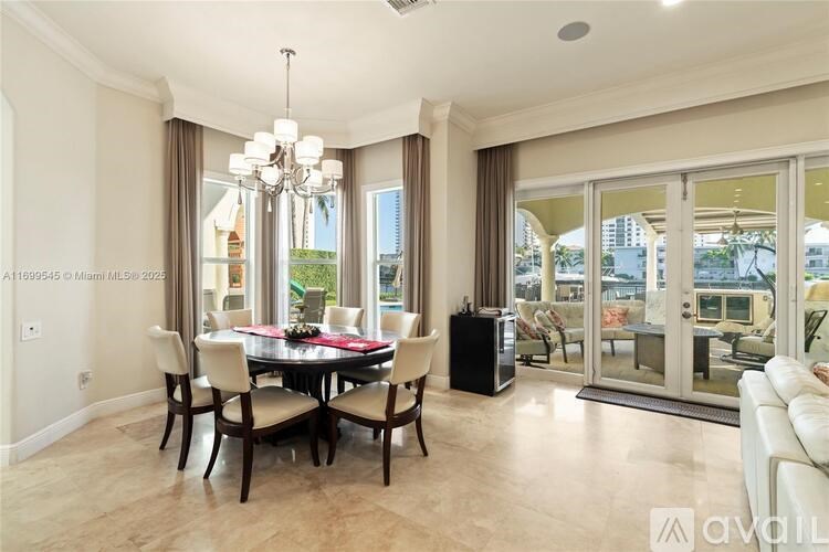 A dining room with a table set for six and a chandelier hanging from the ceiling.