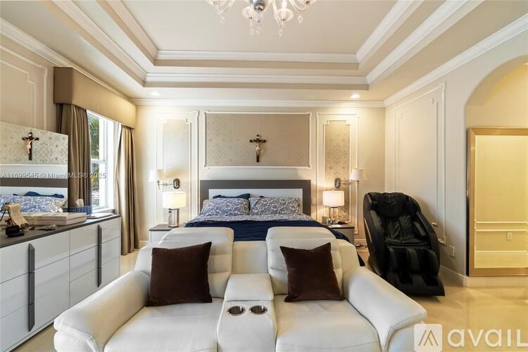 A bedroom with a large bed, a couch, and a kitchen area.