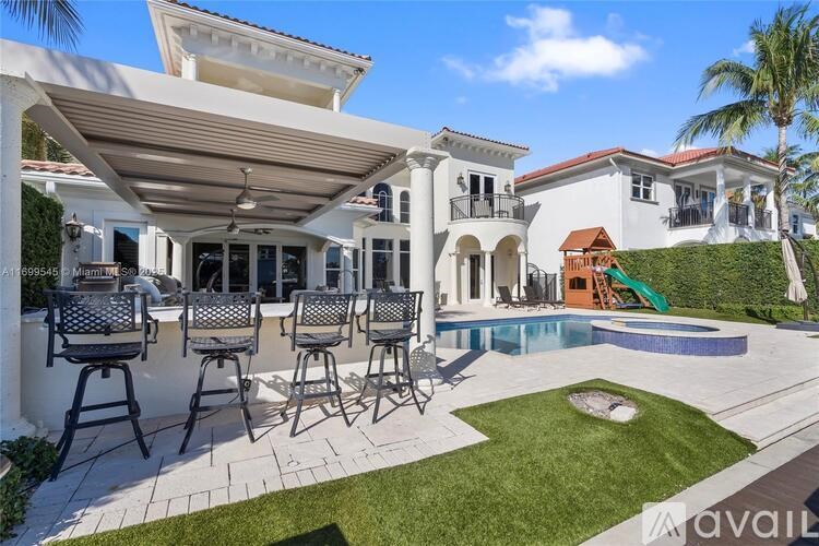 A white house with a pool and patio furniture.