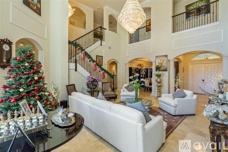 A living room with a Christmas tree and a staircase.