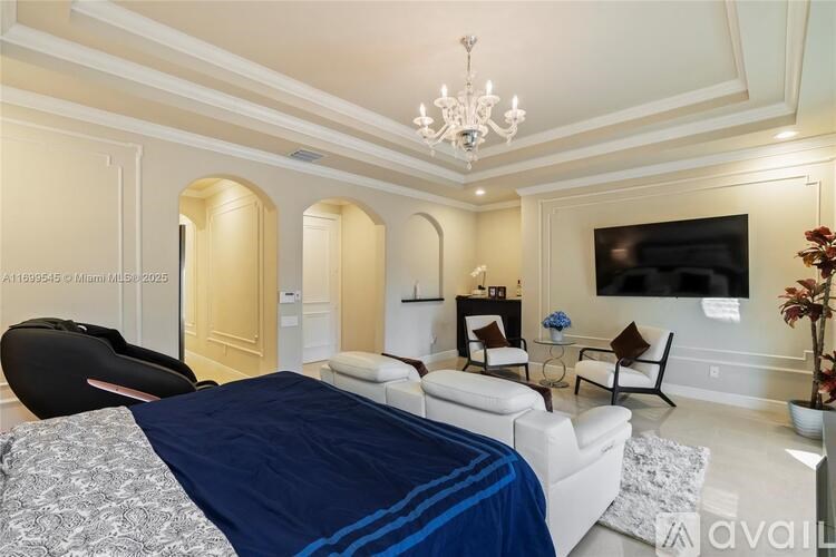 A bedroom with a large bed and a chandelier.