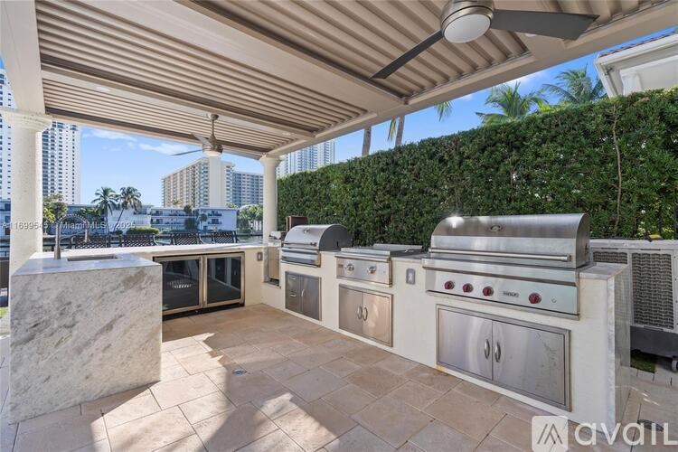 A patio with a grill and a hedge.