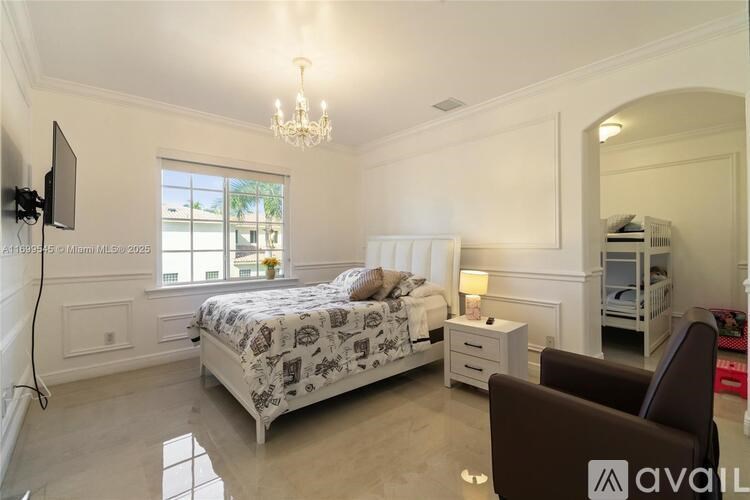 A bedroom with a large bed, a chair, and a television.