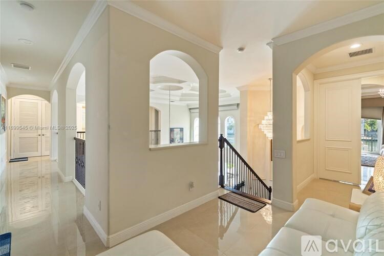 A spacious living room with a staircase and a glass table.