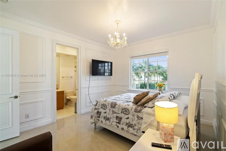 A bedroom with a large bed and a chandelier.