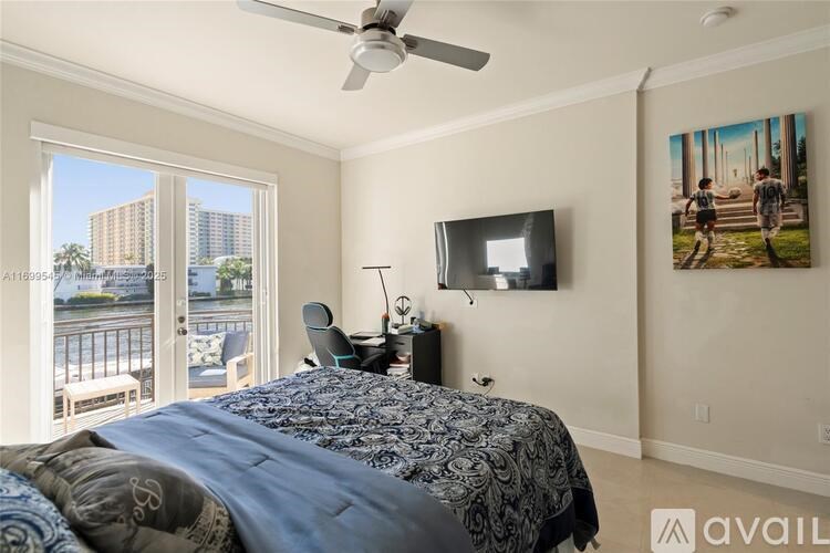 A bedroom with a large bed and a television on the wall.
