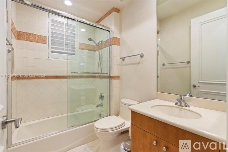 A bathroom with a toilet, sink, and shower.