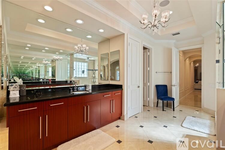 A bathroom with a vanity and a chair.
