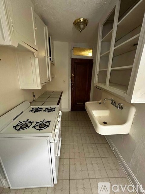 A small kitchen with a white stove and a white sink.