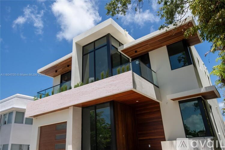 A modern house with a balcony and a brown door.