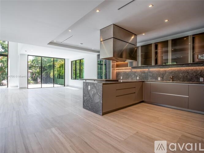 A modern kitchen with wooden floors and a marble countertop.