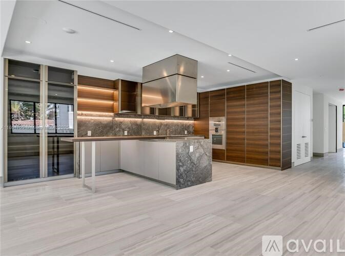 A modern kitchen with wooden cabinets and a marble island.