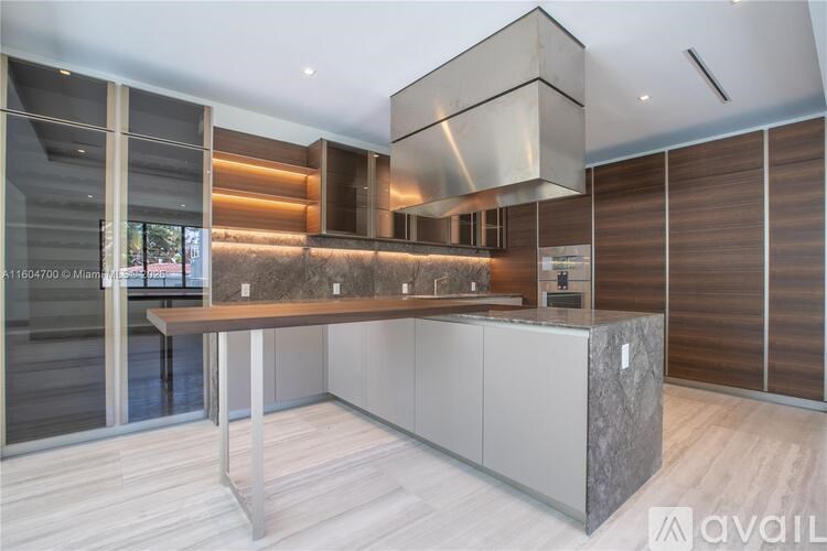 A modern kitchen with a large island and wooden cabinets.