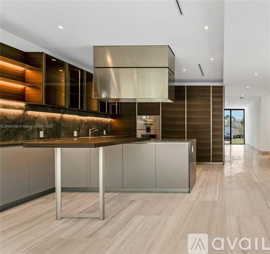 A modern kitchen with a wooden floor and a large island.
