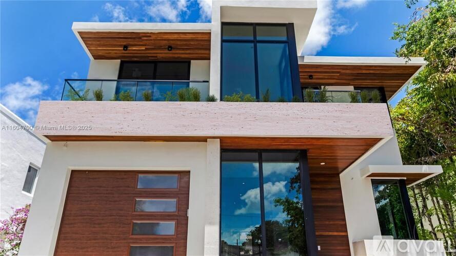 A modern house with a balcony and a glass door.
