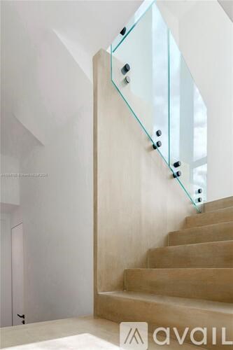 A staircase with a glass railing and wooden steps.