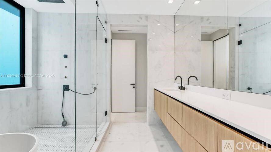 A modern bathroom with a walk-in shower and a large mirror.