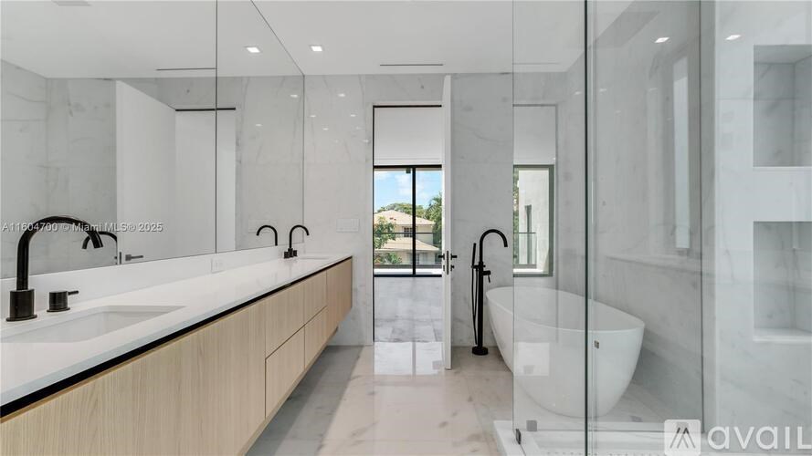 A modern bathroom with a marble countertop and a walk-in shower.