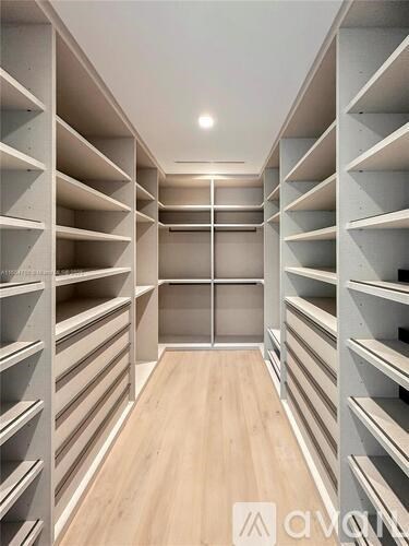 A long, narrow walk-in closet with wooden shelves and a white ceiling.