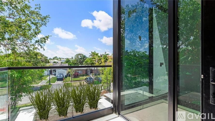 A balcony with glass doors overlooking a residential area.