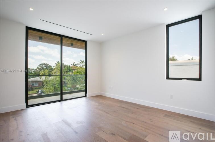 A spacious room with a sliding glass door leading to a backyard.