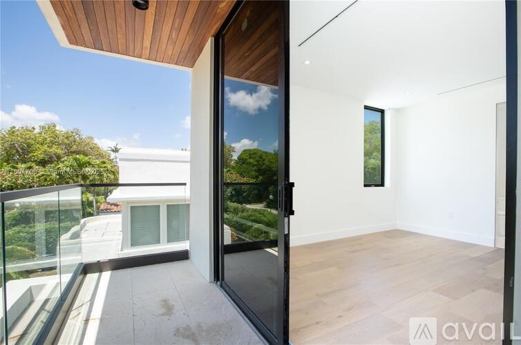 A modern house with a balcony and glass door.