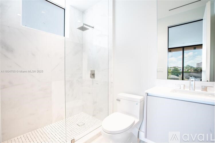 A white toilet is in a bathroom with a glass shower door.