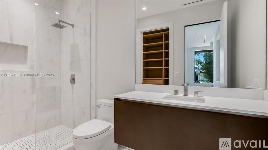 A modern bathroom with a toilet, sink, and mirror.